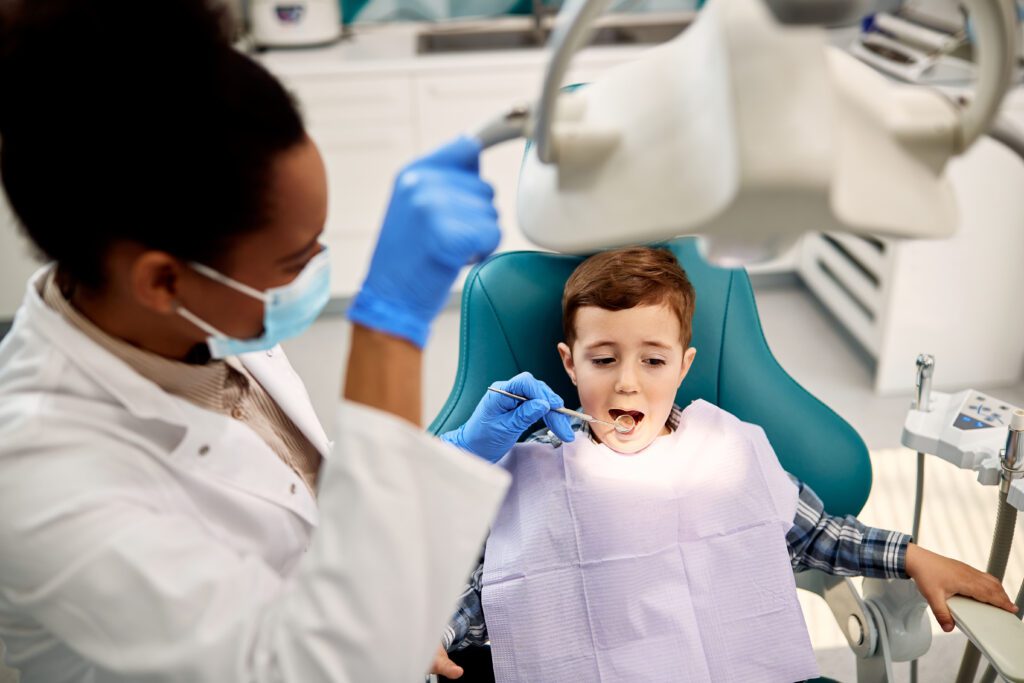 Little boy having teeth check-up at dentist's office.